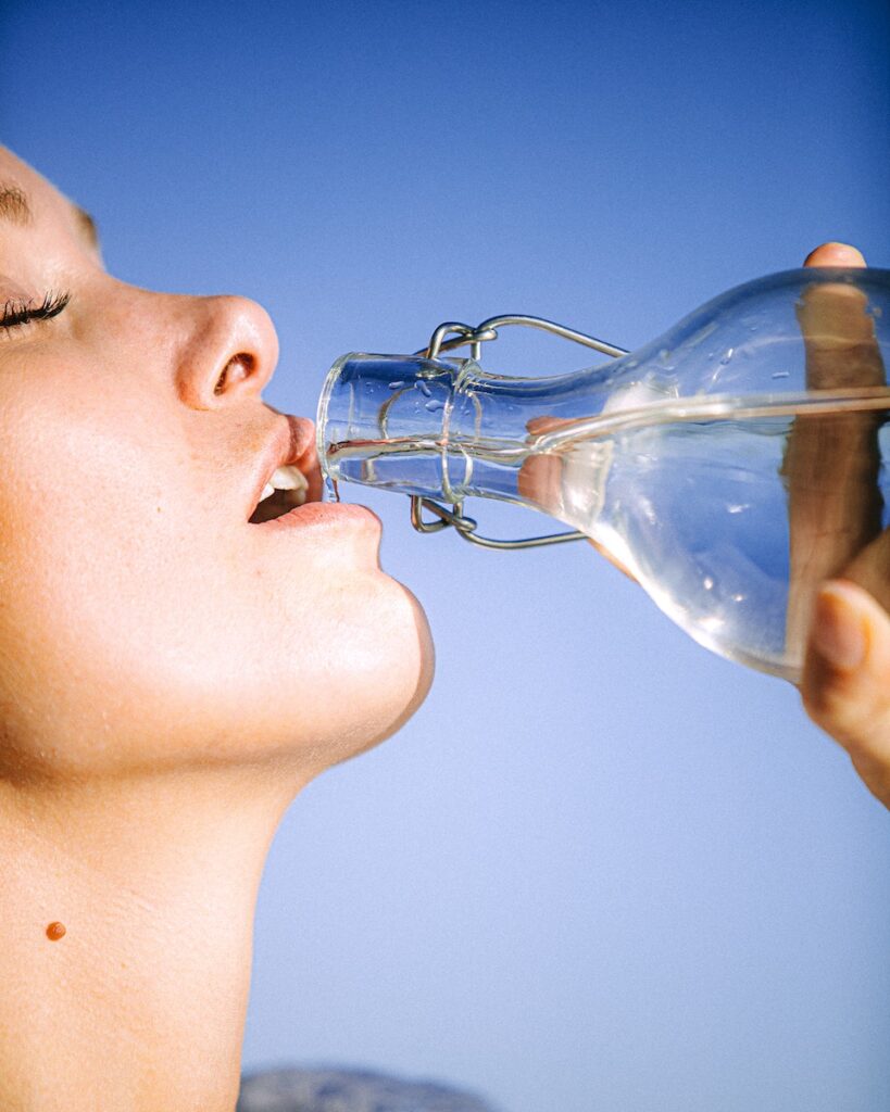 The many benefits of hydration - Woman Drinking Water From Glass Bottle