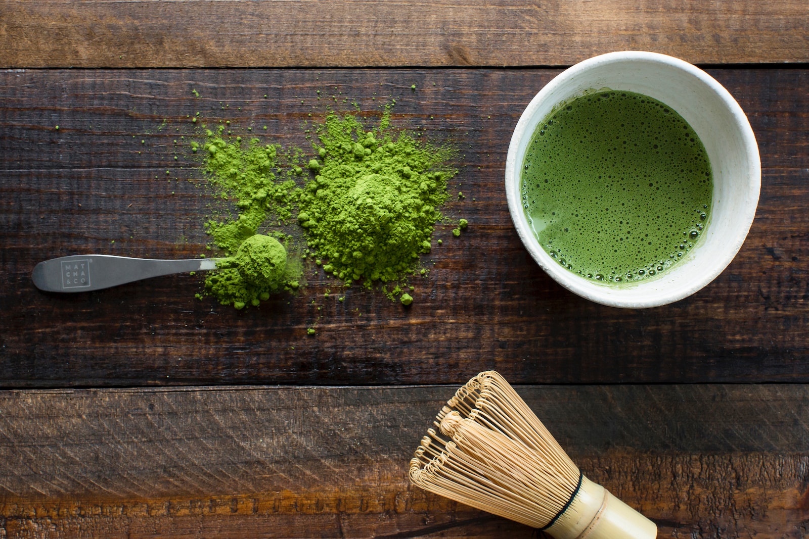 10 Surprising Benefits Of Matcha Green Tea You Need To Know - green plant in white ceramic mug beside brown wooden brush